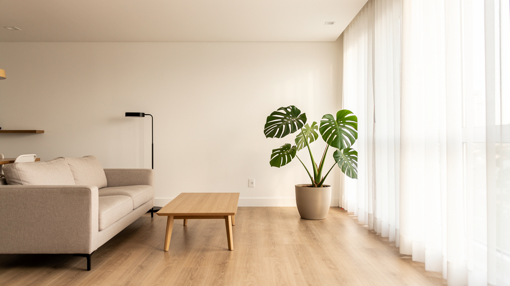 Como investir ao comprar, reformar e vender imóveis 3 Corretor de imóveis apresentando sala de apartamento recém-reformado em Goiânia para cliente